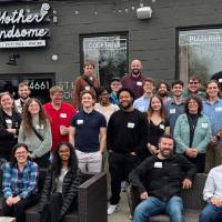 Alumni pose for group photo outside Mother Handsome